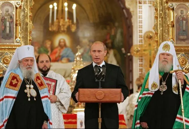 Wladimir Putin bei der Unterzeichnung des Akts über die kanonische Gemeinschaft zwischen der Russischen Orthodoxen Kirche und der Auslandskirche.